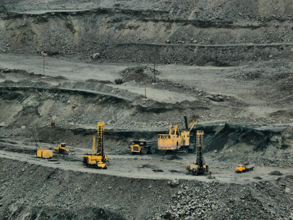 Heavy equipment and haul trucks working an open-pit mine